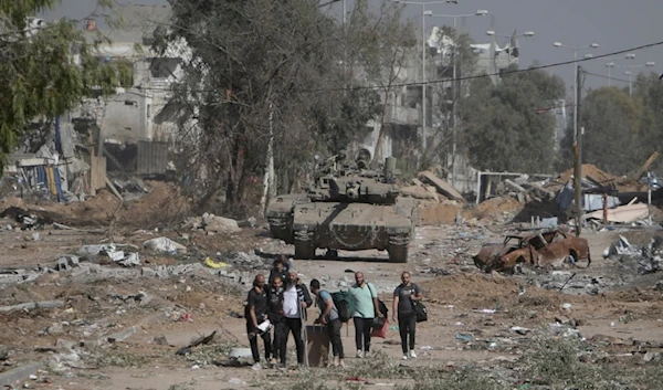 Palestinians flee to northern Gaza as Israeli tanks block the Salah al-Din road in the central Gaza Strip, occupied Palestine, November 24, 2023 (AP)