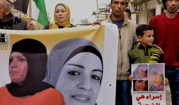 The son of Palestinian detainee Israa Jaabees who has been detained since 2015 and denied medical care on several occasions, participates in a protest for her release in 2018. (Muna Jaabis/Facebook)