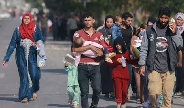 Palestinian families forcibly displaced reach the central Gaza Strip on foot via the Salah al-Din road on 5 November. (AFP via Getty Images)