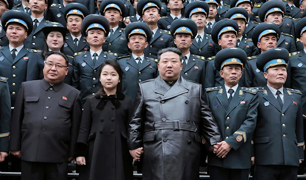 DPRK leader, Kim Jong Un, center, and his daughter, center left, pose with staff of the National Aerospace Technology Administration (NATA) for a group photo, following the launch of a spy satellite in Pyongyang, DPRK, on Nov. 23, 2023 (AP)