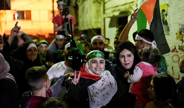 Liberated prisoner Aseel al-Titi sporting a Hamas while she is welcomed by family and friends in Balata refugee camp, Nablus, West Bank, Friday November 24 2023 (AP)