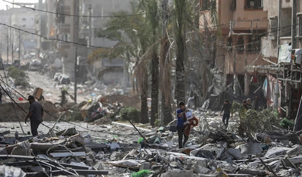 Palestinians walk through Gaza City on Sunday, Nov. 26, 2023 (AP Photo/Mohammed Hajjar)