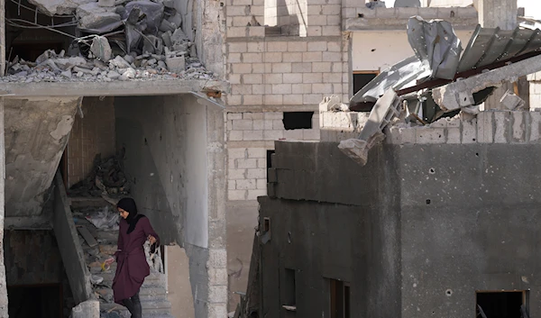 Palestinians visit their homes destroyed in the Israeli bombardment of the Gaza Strip in the village of Khuza'a, east of Khan Younis, Gaza Strip, Sunday, Nov. 26, 2023 (AP)