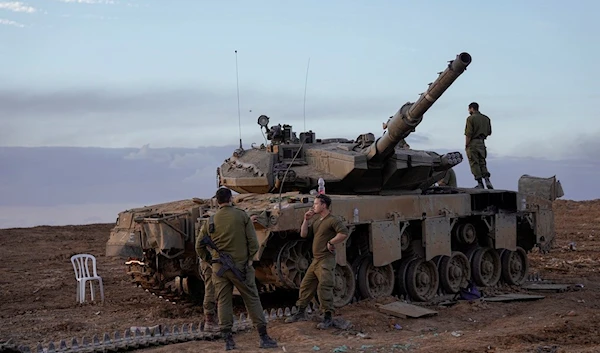 Israeli soldiers work on a tank near the border with the Gaza Strip, southern Israel, Tuesday, Nov. 28, 2023 (AP)