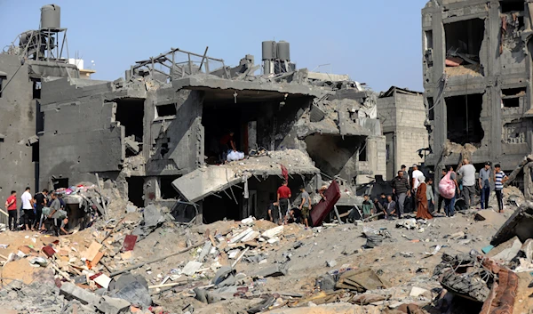 Palestinians stand among debris of buildings that were targeted by Israeli airstrikes in Jabaliya refugee camp, northern Gaza Strip, Wednesday, Nov. 1, 2023. (AP)