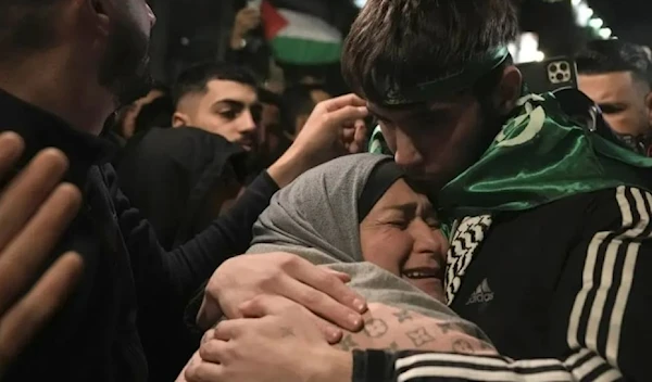 Palestinian child Omar Atshan,17, is hugged by his mother after being released from an Israeli prison in the West Bank town of Ramallah, Sunday Nov. 26, 2023. (AP)