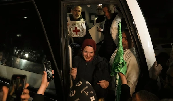 A woman smiles as she is welcomed after being liberated by the Palestinian Resistance, in the occupied West Bank town of Ramallah, November 30, 2023 (AP)