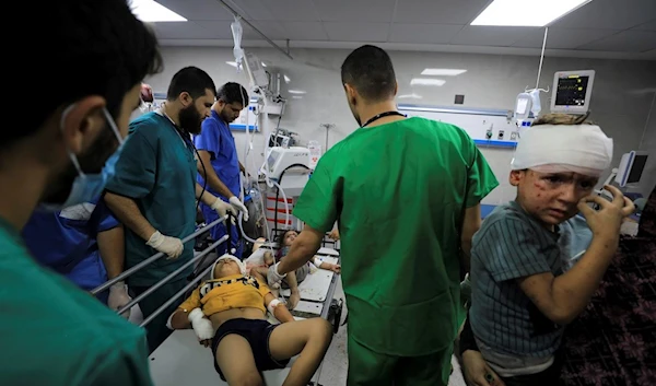 Palestinian medic treats wounded in the Israeli bombardment at Shifa Hospital in Gaza City, Monday, Oct. 23, 2023. (AP Photo/Yasser Qudih)