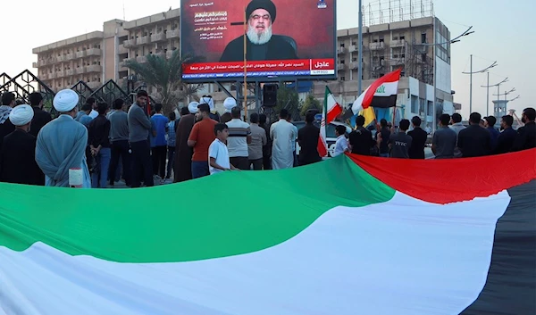 Iraqi demonstrators watch a speech from Lebanon's Hezbollah leader Sayyed Hassan Nasrallah on a screen in Basra, Iraq, Friday, Nov. 3, 2023. (AP)