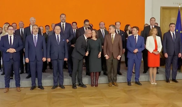 Croatian Foreign Minister Gordan Grlic-Radman tries giving German counterpart Annalena Baerbock a kiss during a family photo at an EU ministerial conference. (AFP)