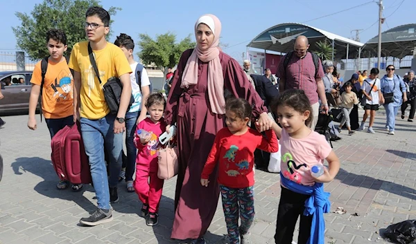 Palestinians cross to the Egyptian side of the border crossing with the Gaza Strip in Rafah Wednesday, Nov. 1, 2023. (AP Photo/Hatem Ali)