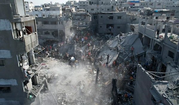 Palestinians look for survivors of the Israeli bombardment in the Maghazi refugee camp in the Gaza Strip, occupied Palestine, November 5, 2023 (AP)