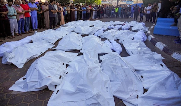 Palestinians mourn relatives killed in the Israeli bombardment of the Gaza Strip in front of the morgue in Deir al Balah, Monday, Nov. 6, 2023. (AP)