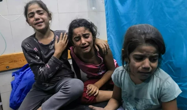 Palestinian children injured in an Israeli air strike await treatment at a hospital in Khan Yunis in southern Gaza, on 17 October 2023 (AFP)