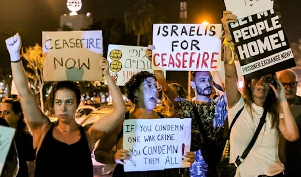 People gather with signs calling for a ceasefire during a protest for the release of Israeli captives in “Tel Aviv” on October 28, 2023. (AFP)