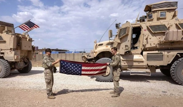 US occupation soldiers fold a flag after returning from patrol to a remote combat outpost known as RLZ on May 25, 2021 in northeastern Syria. (AFP)