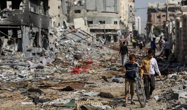 Palestinian children walk through destruction due to brutal Israeli airstrikes on residential areas in Gaza last week. (AP)