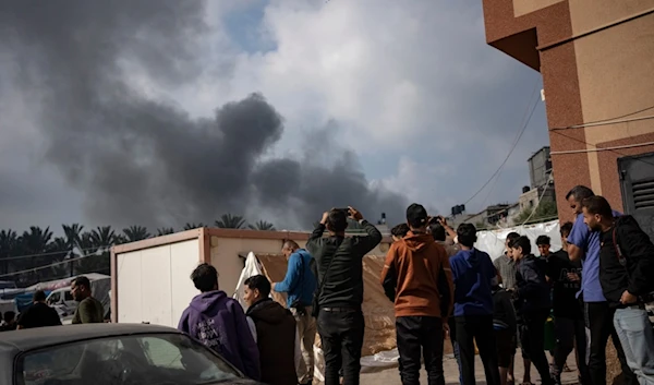 Palestinians look at smoke following an Israeli airstrike in Khan Younis, Gaza Strip, Friday, Dec. 1, 2023. (AP Photo/Fatima Shbair)