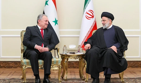 In this photo released by the Iranian Presidency Office, President Ebrahim Raisi, right, meets with Syrian Prime Minister Hussein Arnous at his office in Tehran, Iran, December 9, 2023 (AP)