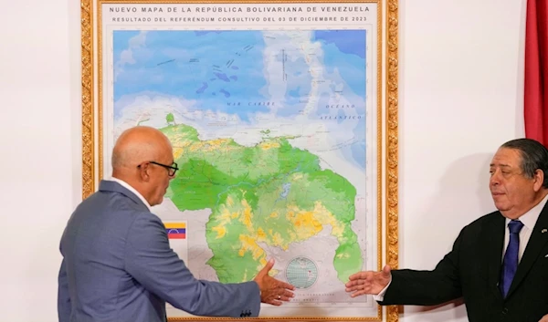 National Assembly President Jorge Rodriguez, left, and Chairman of the Special Commission for the Defense of Guyana Essequibo Hermann Escarra, shake hands after unveiling Venezuela's new map Caracas, Venezuela, Friday, Dec. 8, 2023 (AP)