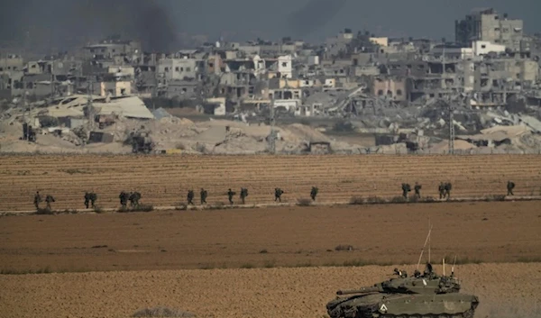 Israeli troops are seen near the Gaza Strip border, in southern Occupied Palestine, Sunday, Dec. 10, 2023 (AP)