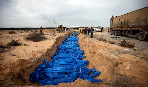 Palestinians bury people killed in the Israeli bombardment who were brought from the Shifa hospital, in a mass grave in the town of Khan Younis, southern Gaza Strip, Wednesday, Nov. 22, 2023. (AP)