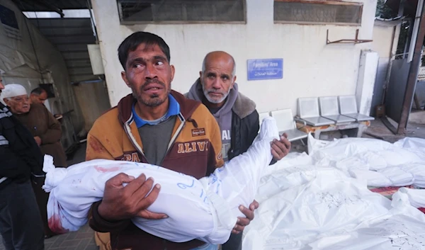 A Palestinian mourns relatives killed in the Israeli bombardment of the Gaza Strip at a morgue in Rafah on Tuesday, Dec. 12, 2023 (AP Photo/Hatem Ali)