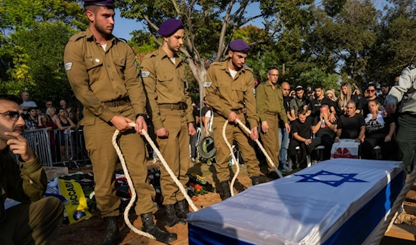 Israeli occupation soldiers lower the coffin of an Israeli occupation officer at the cemetery in occupied Palestine, Thursday, Nov. 2, 2023. (AP)