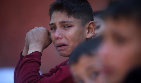 A Palestinian boy cries for his relatives who were killed in the Israeli bombardment of the Gaza Strip, at Nasser hospital in Khan Younis, Friday, Dec. 15, 2023 (AP)