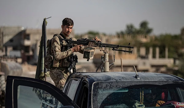 A U.S.-backed Syrian Democratic Forces (SDF) fighter stands on his armored vehicle, at al-Sabha town in the eastern countryside of Deir el-Zour, Syria, Monday, Sept. 4, 2023 (AP Photo/Baderkhan Ahmad)