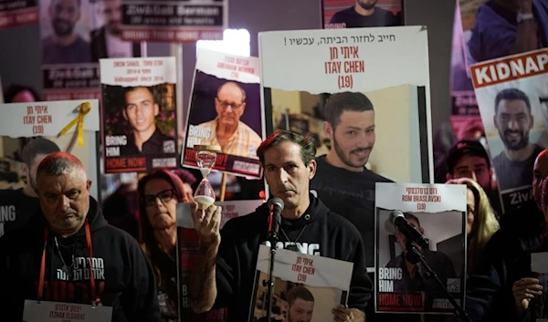 Ruby Chen, center, father of Israeli captive Itay Chen, 19, held by Hamas, holds an hourglass during a rally calling for the return of the captives, in "Tel Aviv", Palestine, Dec. 16, 2023. (AP)