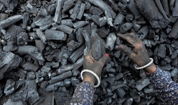 A woman works at a coal depot in Ahmedabad, India, Monday, May 2, 2022. (AP)