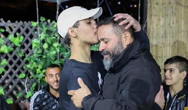 Palestinian child Mohammad Al-Awar left kisses his father’s forehead after being freed by Hamas on November 26. (AFP)