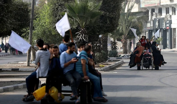 Palestinians on donkey carts hold up white flags trying to prevent being shot while fleeing Gaza City on the al-Rimal neighborhood, central Gaza City, November 8, 2023 (AP)