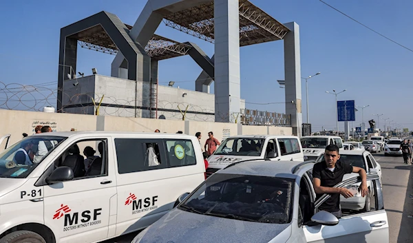 Vehicles wait outside the gate of the Rafah border crossing with Egypt in the southern Gaza Strip on November 1, 2023 (AFP)