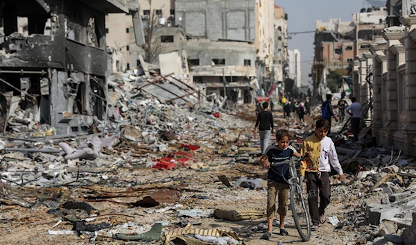 Palestinians walk through destruction in Gaza City on Friday, Nov. 24, 2023, as the temporary ceasefire takes effect. (AP)