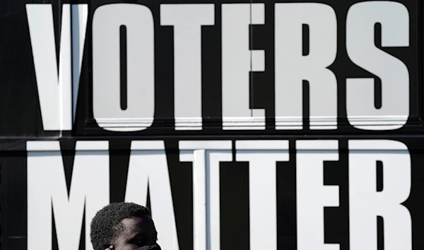 A man wearing a mask gathers with a group in support of Black Voters Matter at the Graham Civic Center polling site in Graham, N.C., Nov. 3, 2020. (AP)