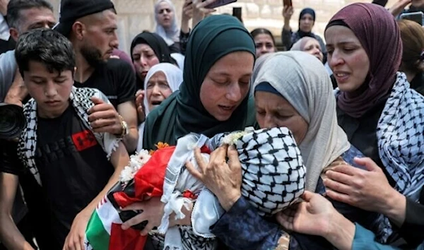 The mother (C) of Mohammed Haitham al-Tamimi, a 2.5-year-old Palestinian child shot by the IOF a week earlier, carries his body during his funeral in the village of Nabi Saleh, June 6, 2023. (AFP)