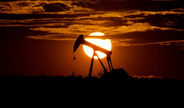 The sun sets behind an idle pump jack near Karnes City, USA, April 8, 2020. (AP)