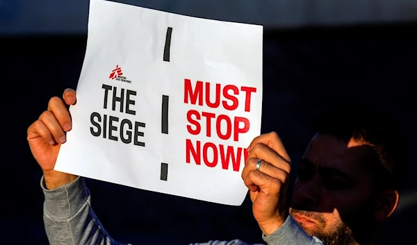 A member of international humanitarian group Doctors Without Borders holds a placard during a protest called for an end to the war in Gaza and for an immediate cease-fire, at Martyrs' Square in downtown Beirut, Lebanon, Monday, Dec. 4, 2023. (AP)