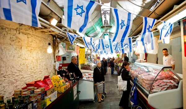 Israeli settlers stand in the market, Occupied Al-Quds, Wednesday, April 22, 2015 (AP)