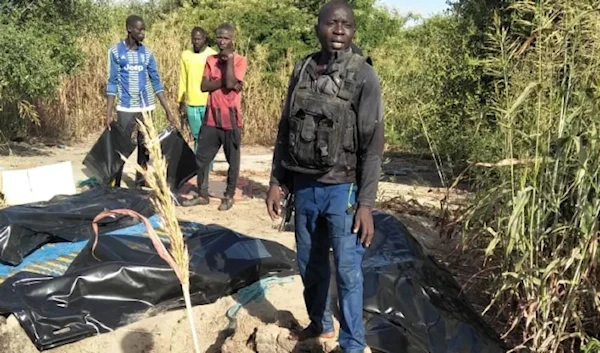 A man stands next to body bags of farmers that were victims of an attack, in the Zabarmari district, near Maiduguri, on November 6, 2023. (AFP)