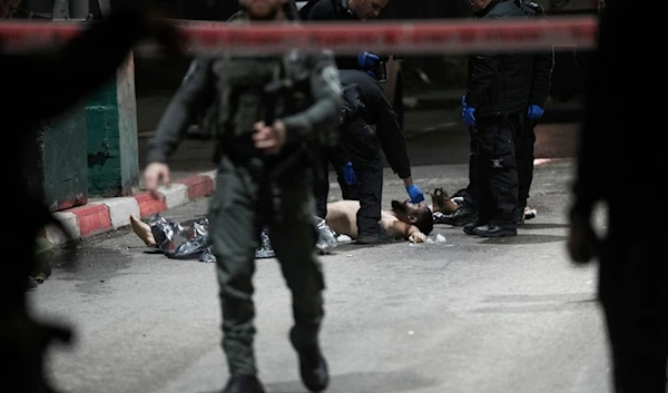 Israeli security forces examine the body of the Palestinian martyr at the scene of a stabbing operation at the "Mazmuria" checkpoint, Thursday, Dec. 28, 2023