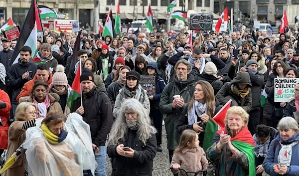 Demonstrators with banners gather at Dam Square and march to Museumplein (Museum Square) to call for a permanent ceasefire in Gaza during a rainy day in Amsterdam, Netherlands on November 26, 2023. (AFP)