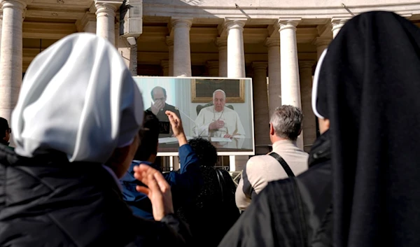 Nuns look at Pope Francis on a giant monitor set up in St. Peter's Square at The Vatican, Sunday, Dec. 3, 2023, as he blesses the faithful gathered in the square for the traditional Angelus noon prayer. (AP)