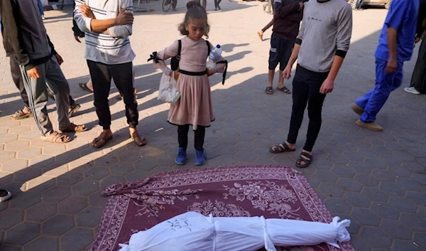 Palestinians mourn relatives killed in the Israeli bombardment of the Gaza Strip in front of the morgue in Deir al Balah on Monday, Dec. 4, 2023 (AP Photo/ Hatem Moussa)