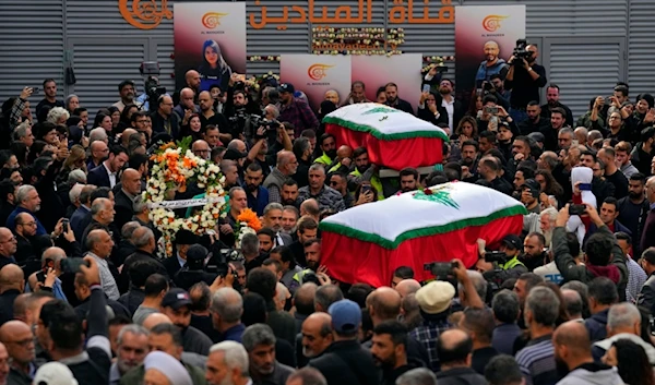 Mourners carry the coffins of the two journalists of pan-Arab TV network Al-Mayadeen who were killed by an Israeli strike, at the station's headquarters, in Beirut, Lebanon, Wednesday, Nov. 22, 2023 (AP)