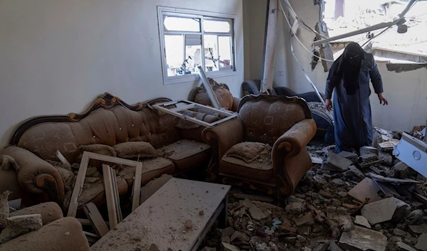 A Palestinian woman inspects a damaged house following Israeli airstrikes on the town of Khan Younis, Gaza, Sunday, Dec. 3, 2023 (AP )