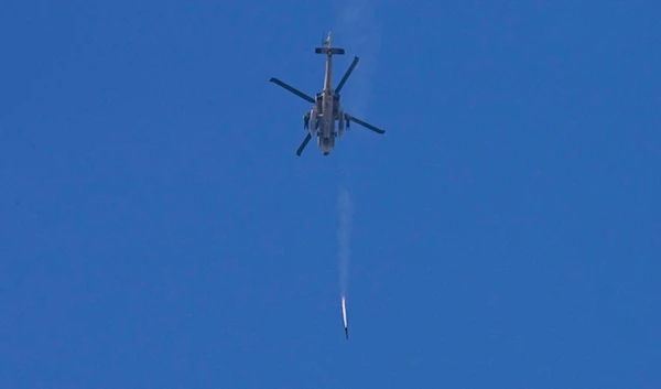 An Israeli Apache helicopter fires a missile in direction of the Gaza Strip, as seen from the occupied territories, Monday, Dec. 4, 2023. (AP Photo/Ohad Zwigenberg)