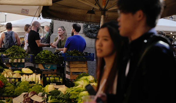 Tourists stroll past market stalls in Campo De' Fiori in Rome, Friday, Oct. 28, 2022. (AP)